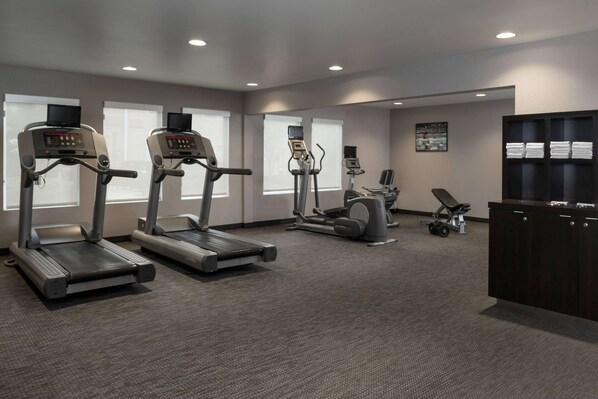 A gym with treadmills, elliptical machines, and a stationary bike.