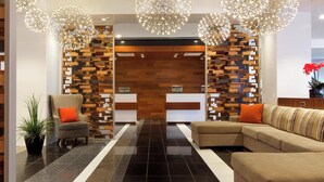 A modern lobby with a reception desk, a sofa, and a chair.