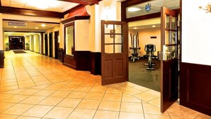 A hotel corridor with a reception area, a fitness center, and a sign for 'MEZZANINE'. - Best Western Park Hotel (Warren)