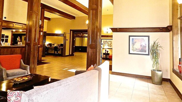 A spacious lobby with high ceilings, wooden beams, a reception desk, and a seating area with a coffee table. - Best Western Park Hotel (Warren)