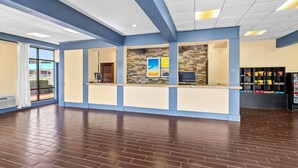 A reception area with a counter, a tiled wall, and a window with a view. - Days Inn by Wyndham Petersburg/South Fort Lee (Petersburg)