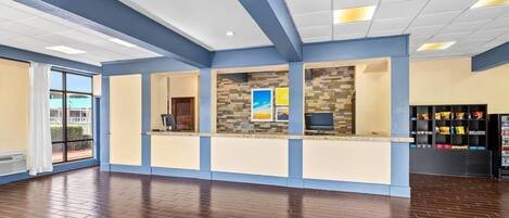 A reception area with a counter, a tiled wall, and a window with a view.