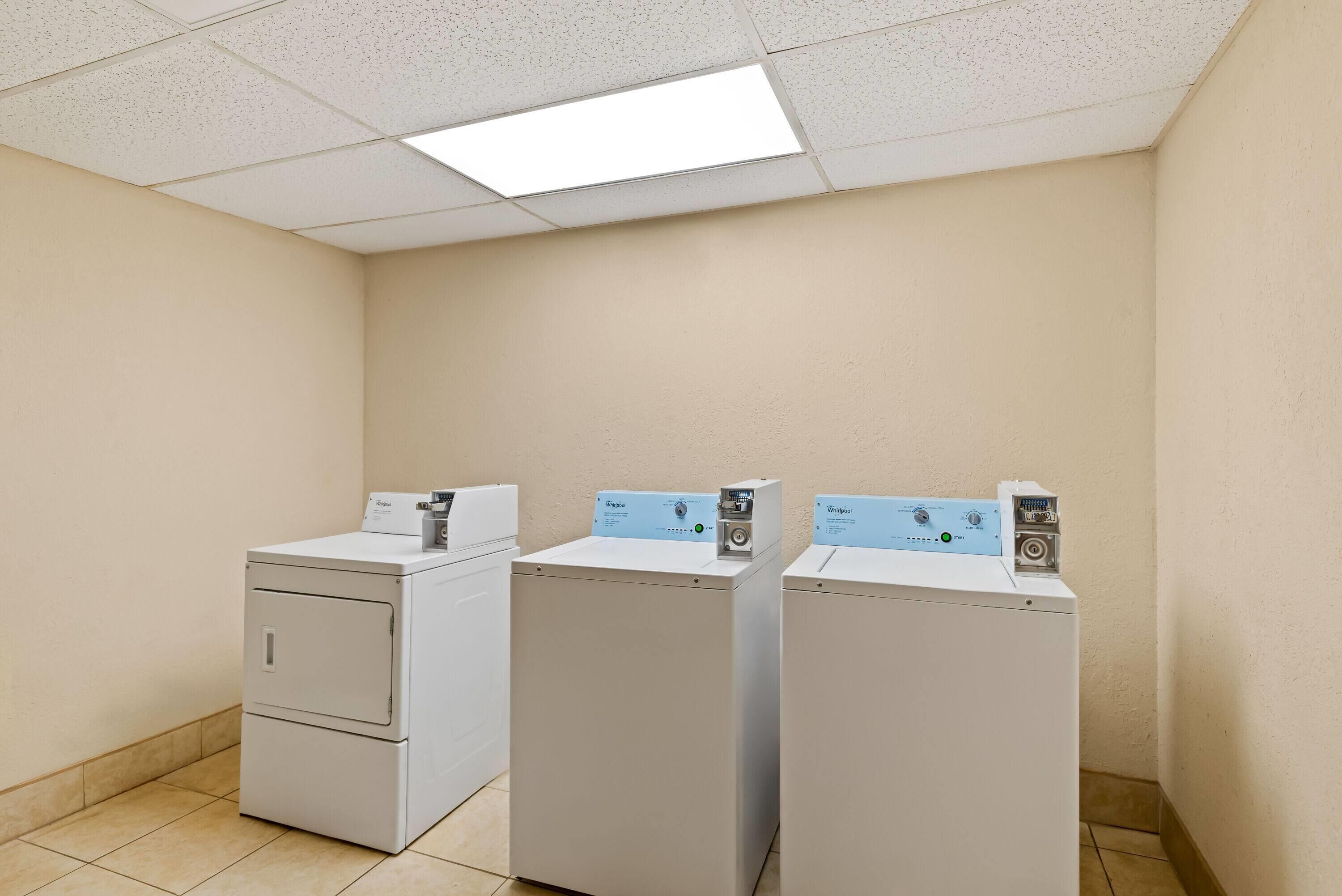 A laundry room with two front-loading washers and dryers.