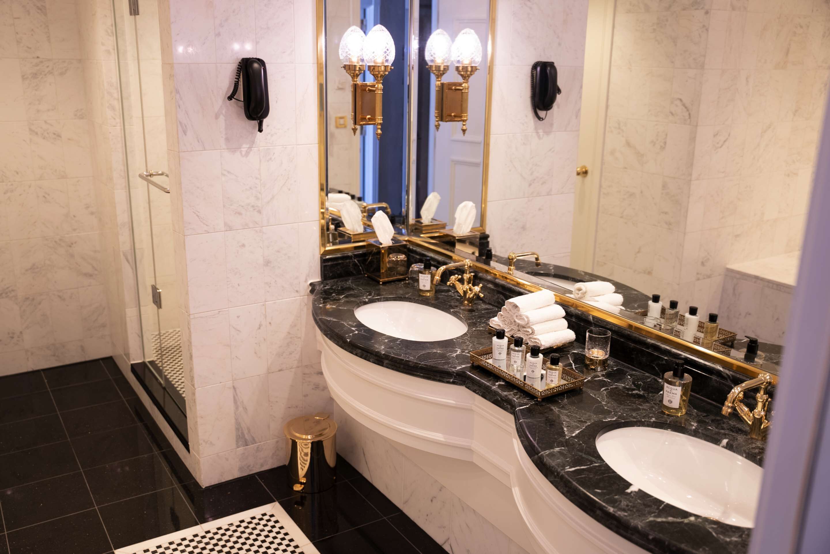 A luxurious bathroom with two sinks, a large mirror, and a vanity area.