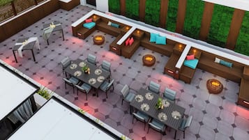 A modern outdoor patio with hexagonal tiles, seating areas, and fire pits.
