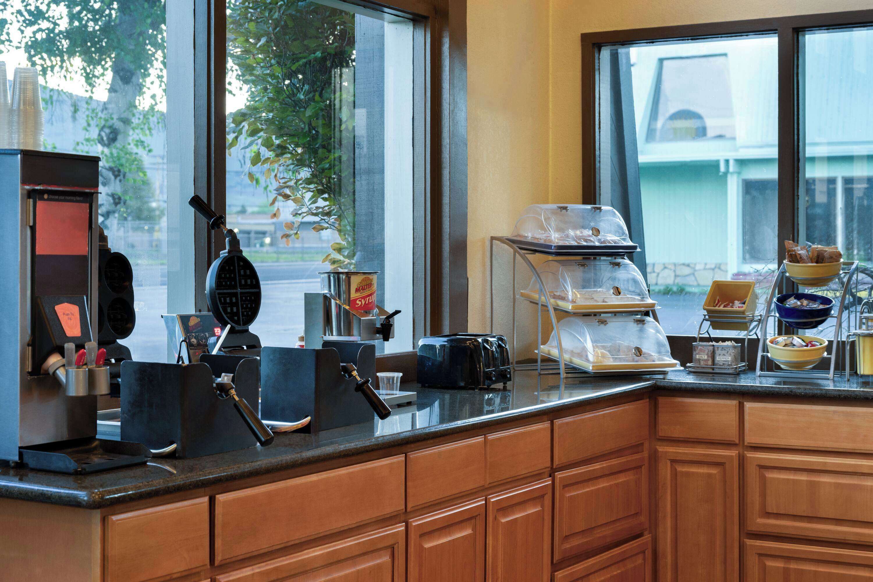 A kitchen counter with a coffee machine, toaster, and various food items.