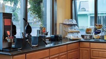 A kitchen counter with a coffee machine, toaster, and various food items.