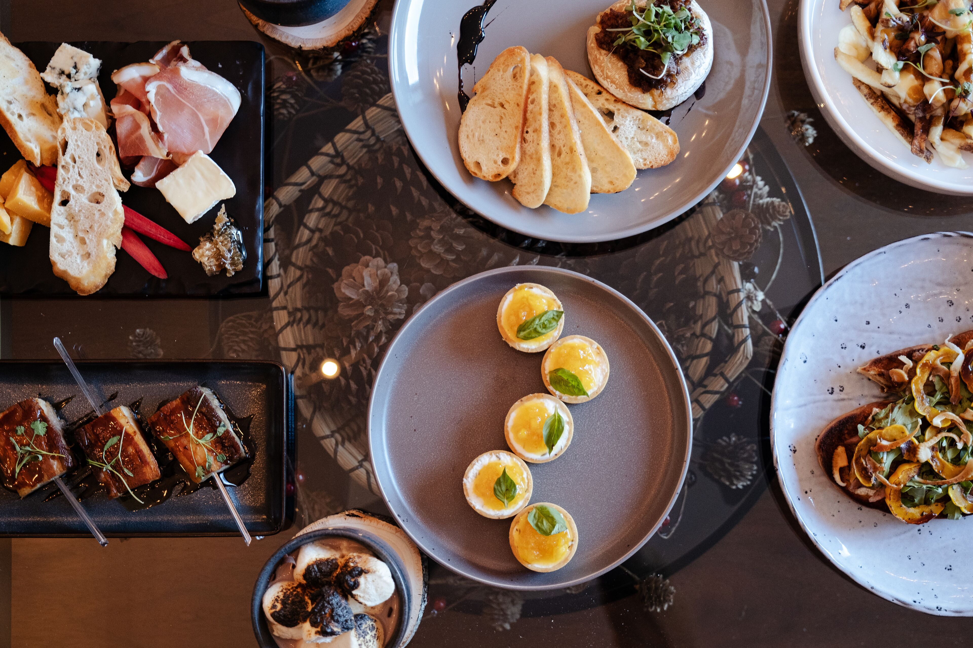 A variety of dishes on a table, including bread, cheese, and meat.