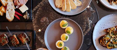 A variety of dishes on a table, including bread, cheese, and meat.