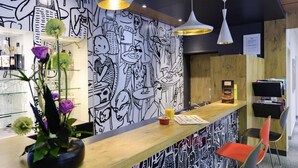 A bar area with a wooden counter, black and white mural, and modern pendant lighting. - ibis Avignon Centre Pont de l'Europe (Avignon)
