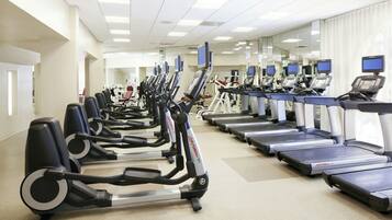 A gym with multiple treadmills and elliptical machines.