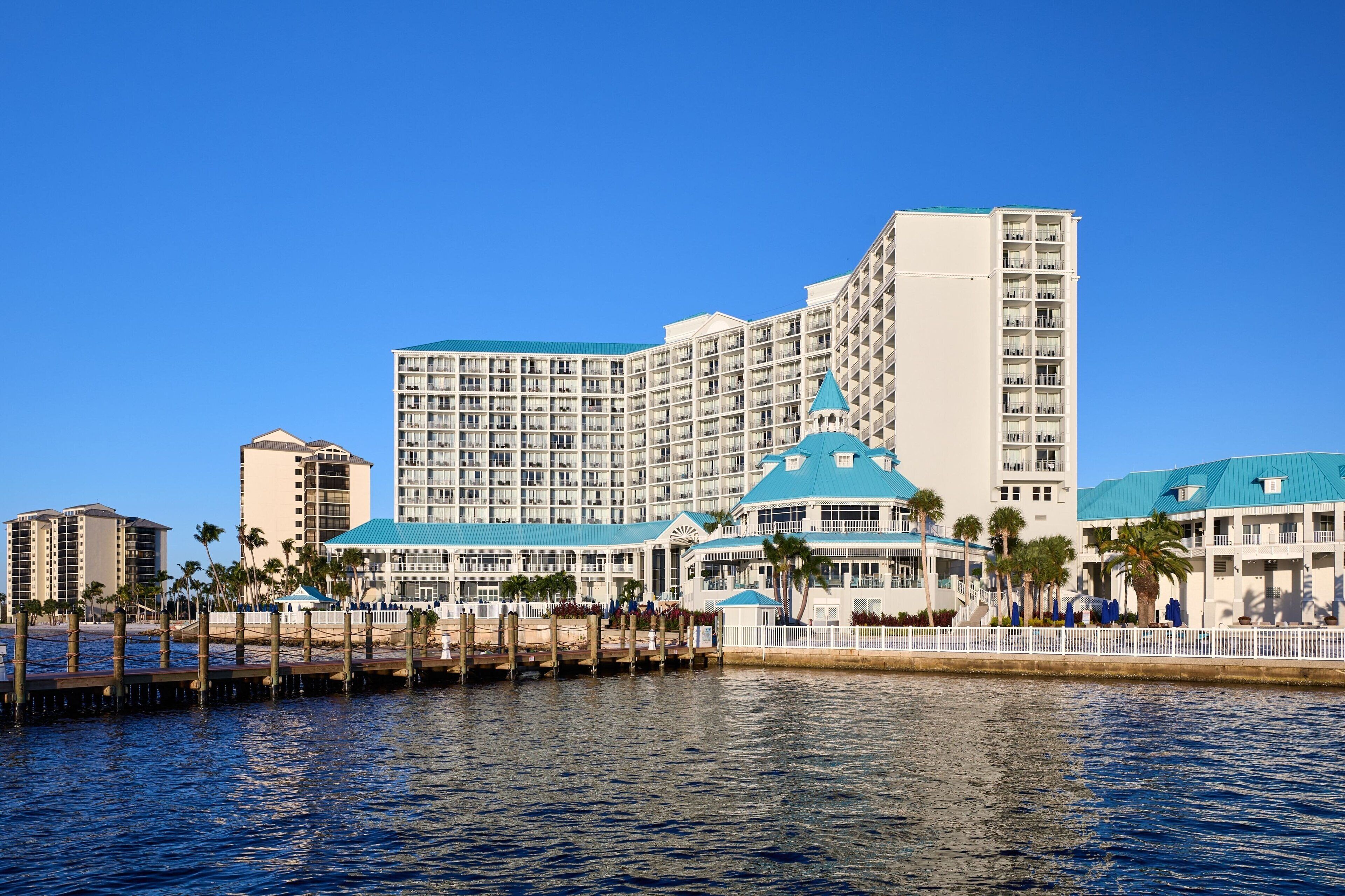 A large hotel with multiple floors, a prominent blue dome structure, and a waterfront location.