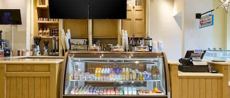 Una vitrina de panadería con diversos productos horneados y bebidas.
