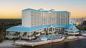 Ein großes Hotel mit mehreren Etagen, einem Pool und einer Strandanlage.