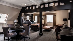A spacious living area with a high ceiling, a round table with chairs, a sofa, and a piano. - The Vermont Hotel Newcastle (Newcastle-upon-Tyne)