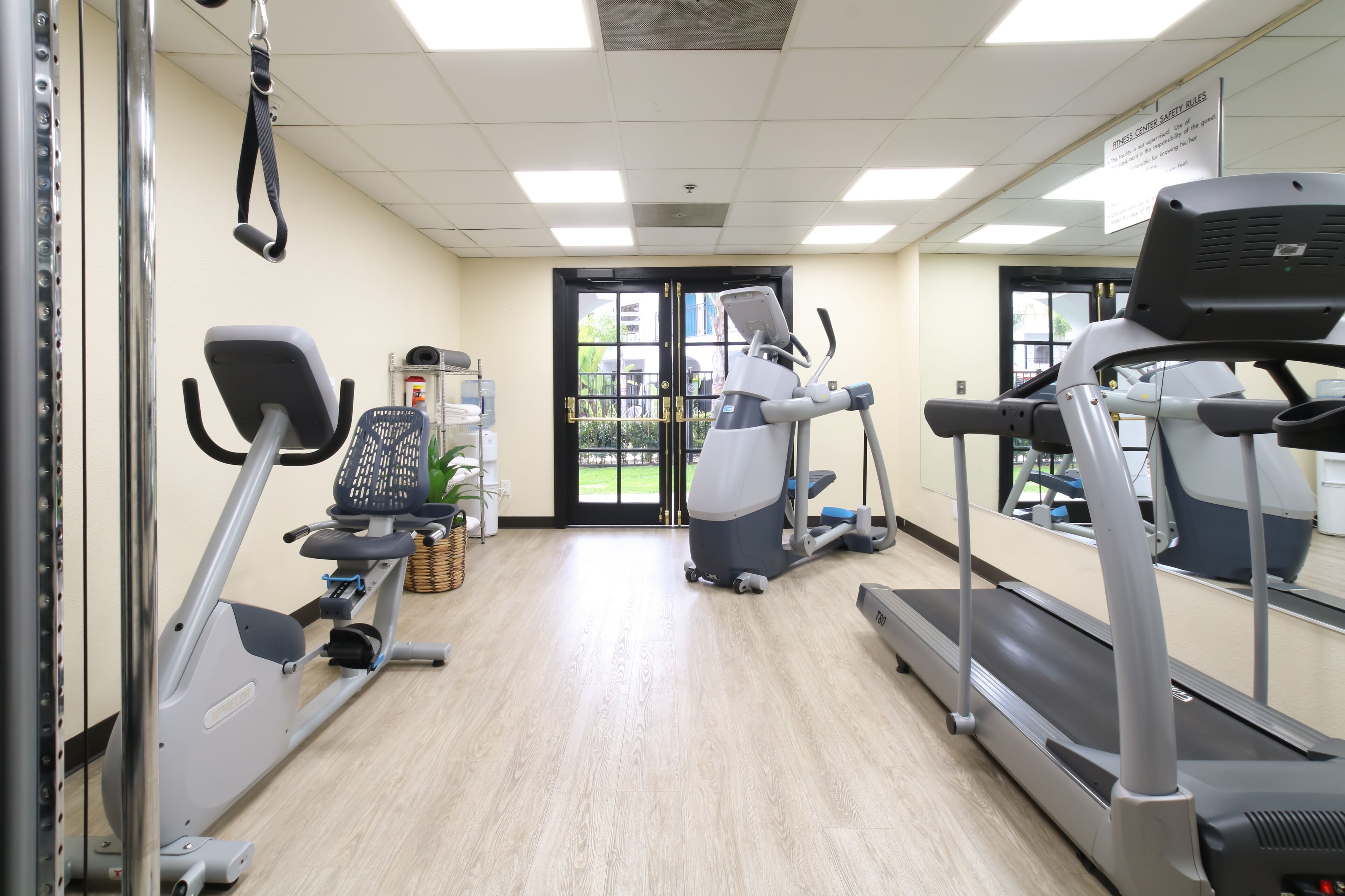 Ein Fitnessstudio mit Laufbändern, Crosstrainern und einem Ergometer.