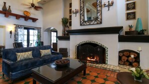 Una sala de estar con chimenea, un sofá, una mesa de centro y un ventilador de techo.