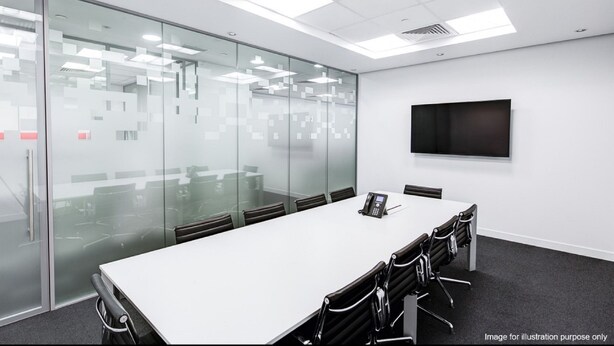 A conference room with a long table, chairs, a phone, and a TV on the wall.