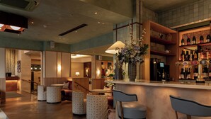 Eine Bar mit Hockern, einer Theke und einer Weinauslage.