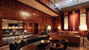 A spacious lobby with a bar area, seating arrangements, and a high ceiling with intricate wood paneling. - Heathman Hotel (Portland)