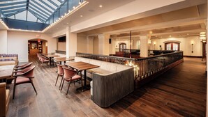 A spacious hotel lobby with a high ceiling, a central seating area, and a glass-paneled atrium. - Heathman Hotel (Portland)