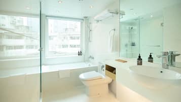 A modern bathroom with a bathtub, toilet, and sink.