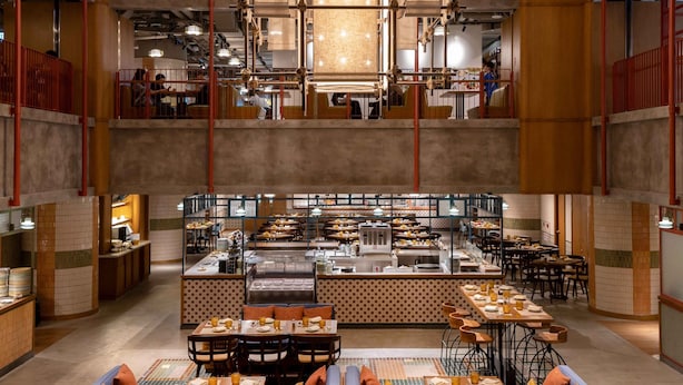 A spacious restaurant with high ceilings, multiple dining areas, and a central kitchen. - Eaton HK (Kowloon)