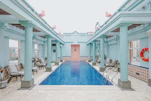 Una piscina al aire libre, sillones reclinables de piscina