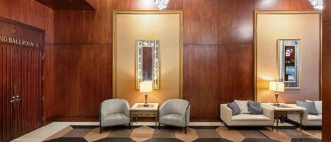 A lobby with a checkered floor, two armchairs, a sofa, a table with a lamp, and a door labeled "Ballroom A".