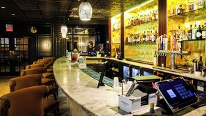 A bar area with a marble counter, bar stools, and a variety of liquor bottles. - Chateau Merrimack Resort & Spa (Tyngsboro)