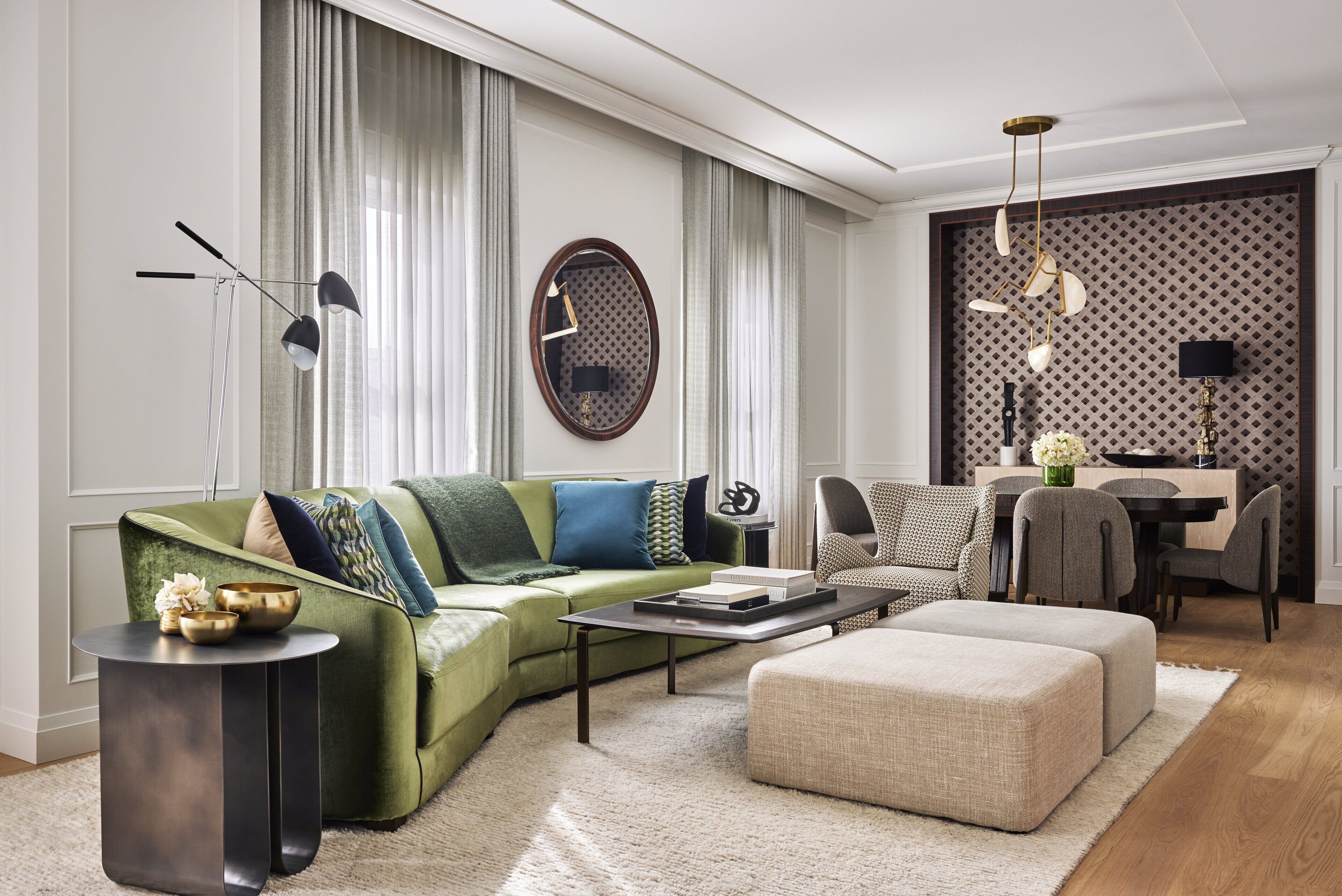 A modern living room with a green sofa, a round coffee table, and a dining area with a table and chairs.