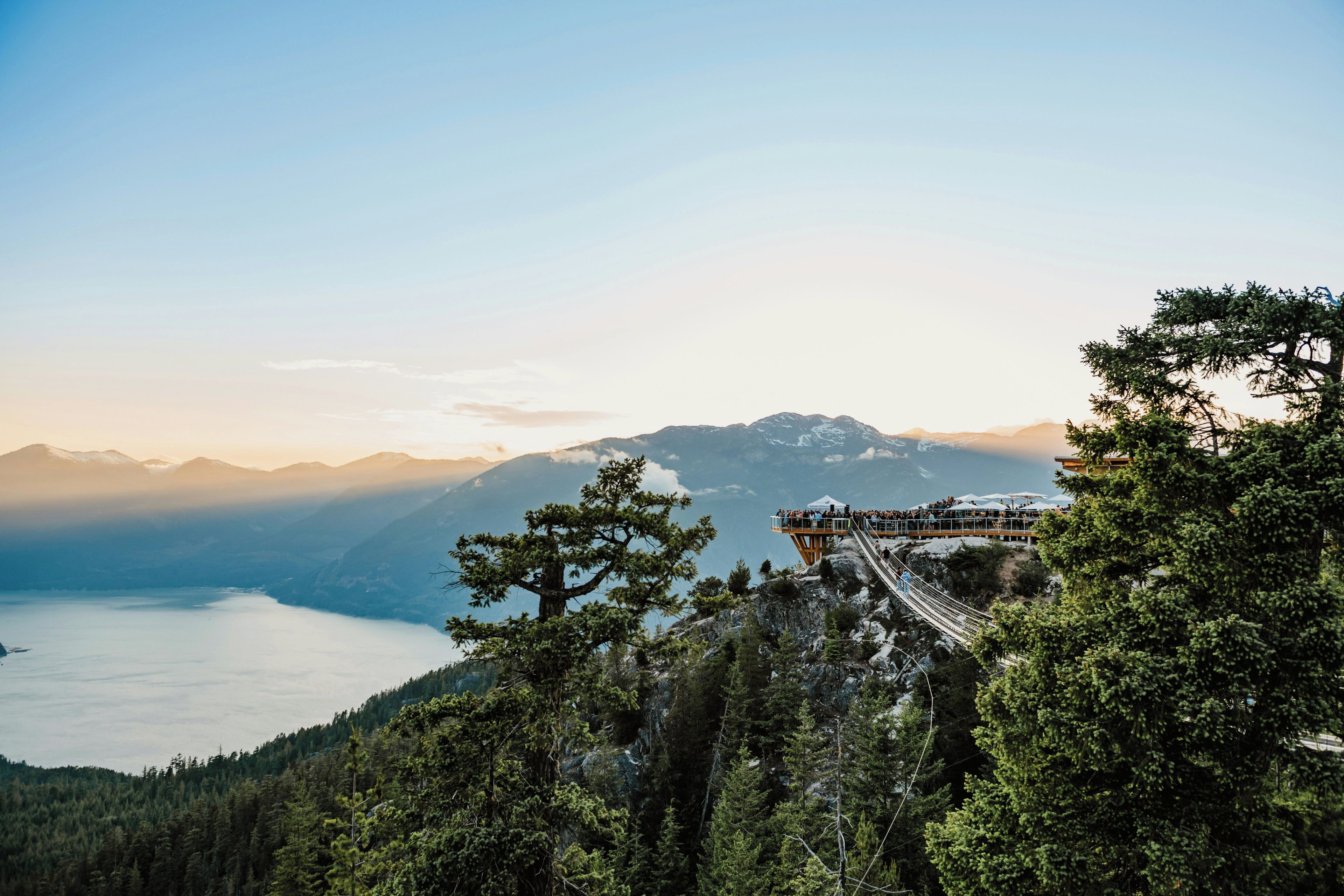 A mountain overlook with a wooden viewing platform and a suspension bridge.
