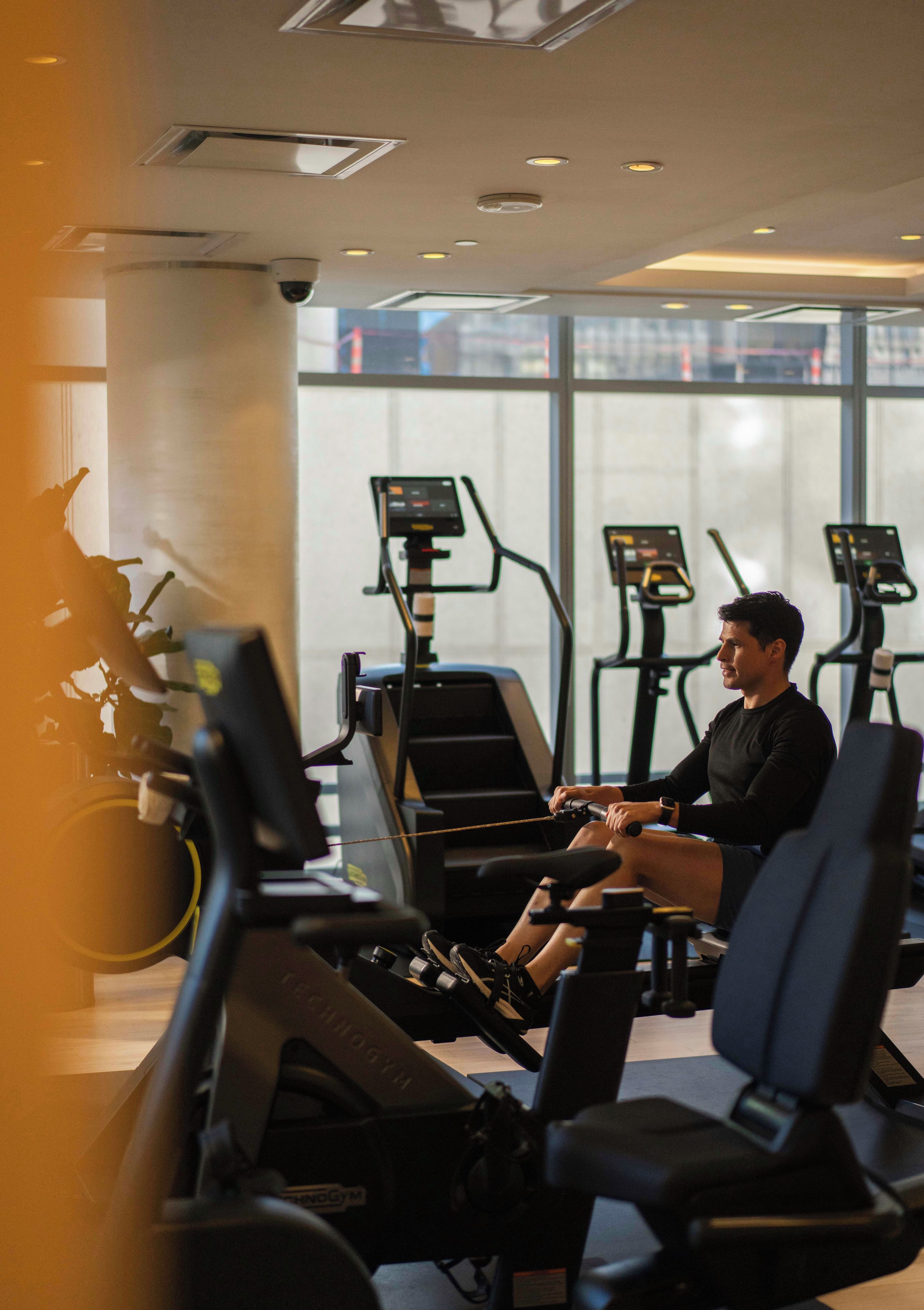 A gym with treadmills and a person using one.