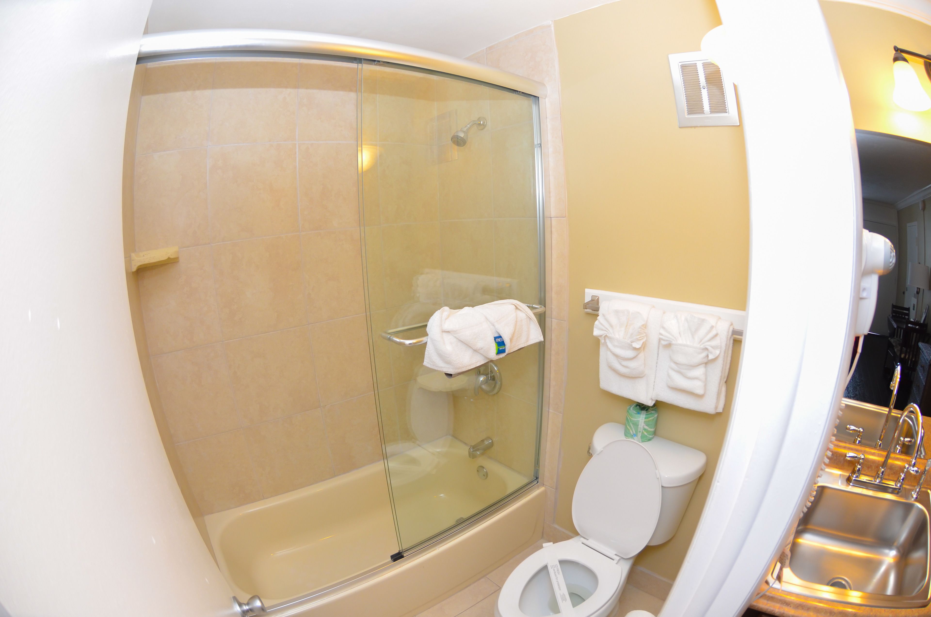 A bathroom with a glass-enclosed shower, a bathtub, a toilet, and a sink.