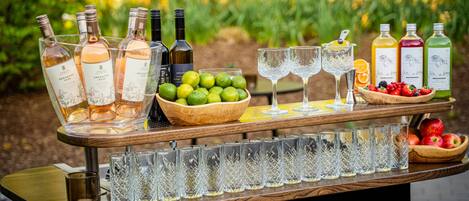 Disposición de bar con botellas, vasos y frutas.