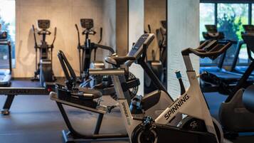 Un gimnasio con bicicletas estáticas y cintas de correr, incluyendo una bicicleta Spinning.