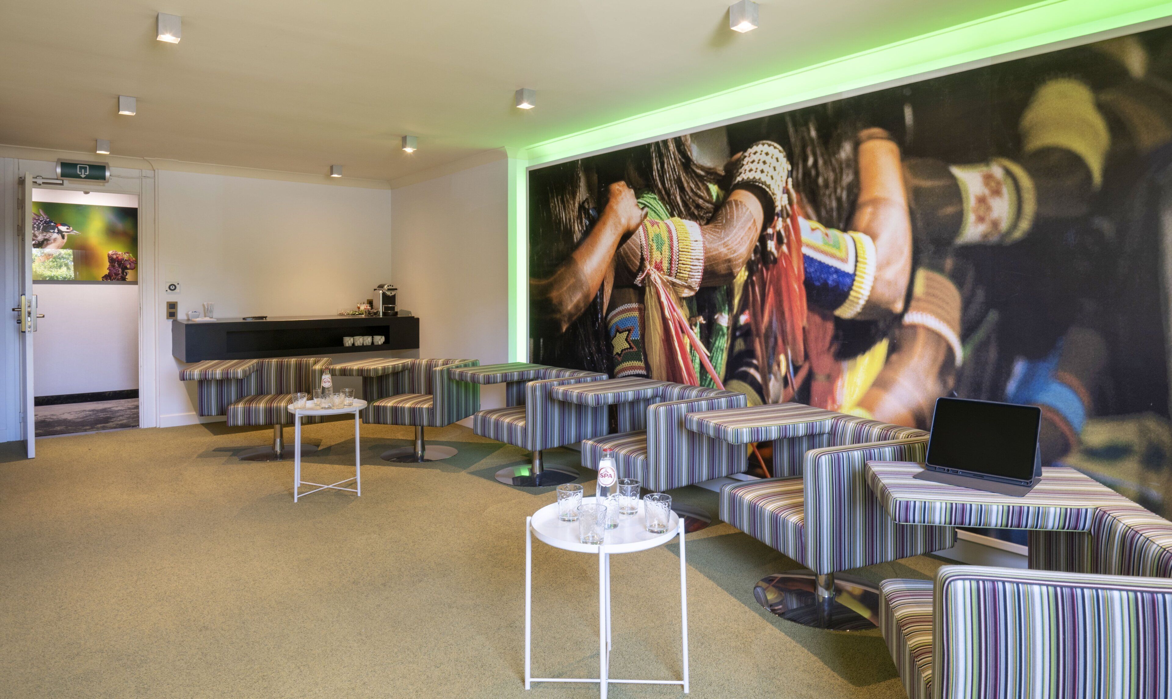 A lobby with striped seating, a large mural, and a reception desk.