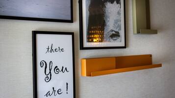 A wall with framed artwork, including a quote and a portrait.