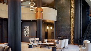 Un vestíbulo amplio con techos altos, muebles modernos y una chimenea.