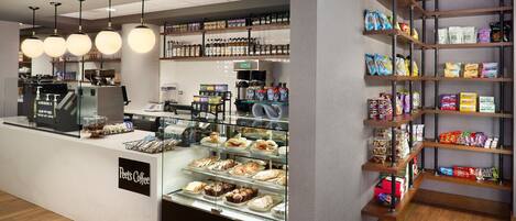 Ein Peet's Coffee Kaffeehaus-Interieur mit einer Theke, Auslagen und Regalen voller Snacks und Getränke.