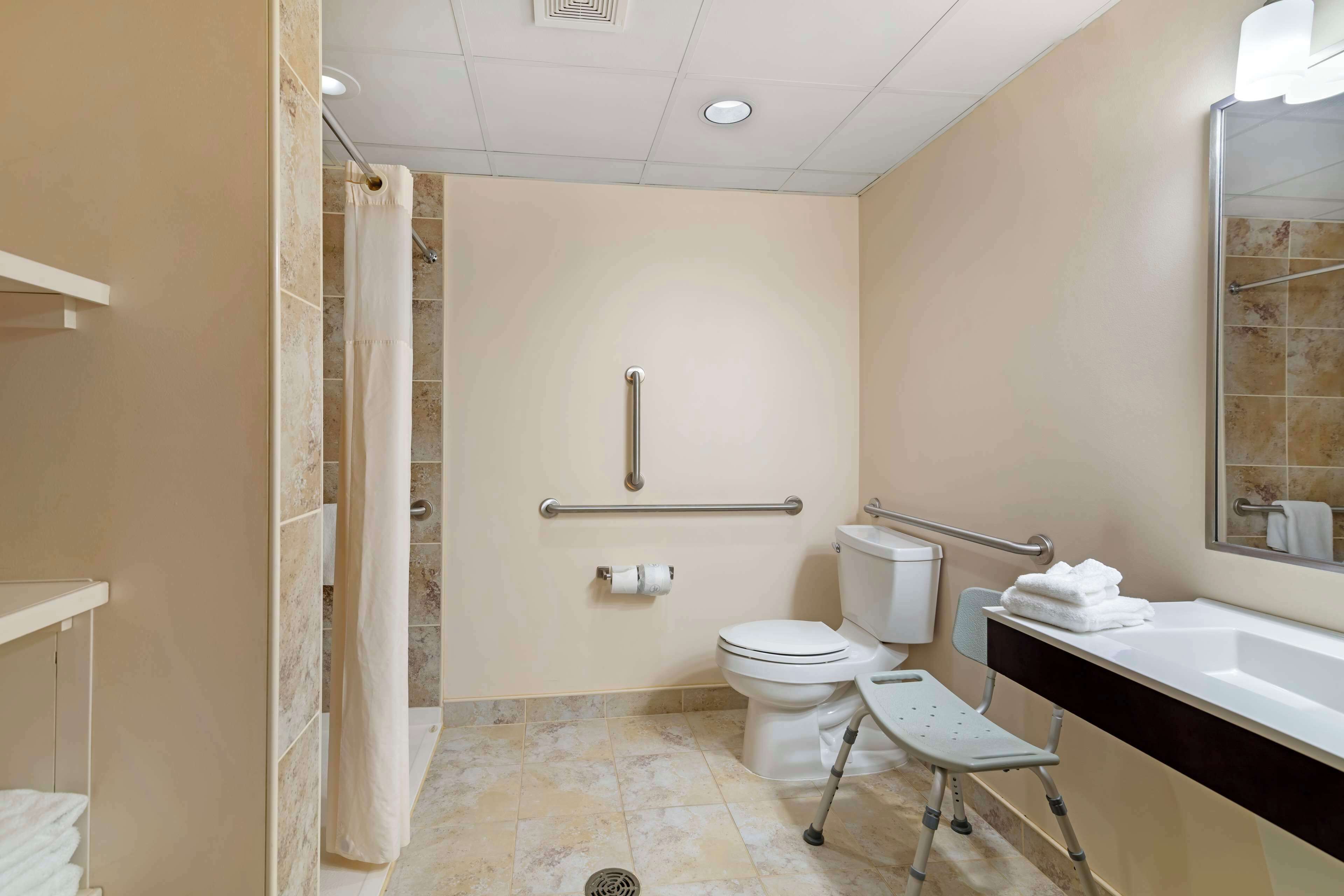 A bathroom with a shower, toilet, and sink.