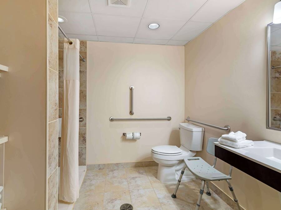 A bathroom with a shower, toilet, and sink.