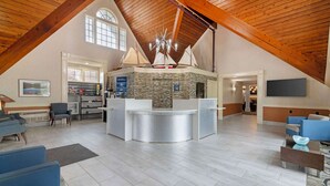 Un loft spacieux avec de hauts plafonds, un îlot central doté d’un pare-feu en pierre et un coin cuisine offrant une vue dégagée.