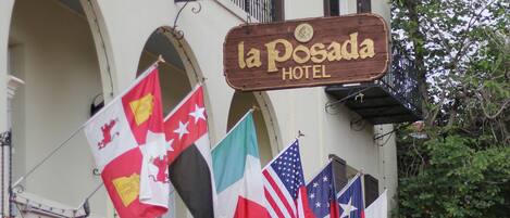 Un hotel con un cartello che riporta 'la Posada Hotel' e diverse bandiere.