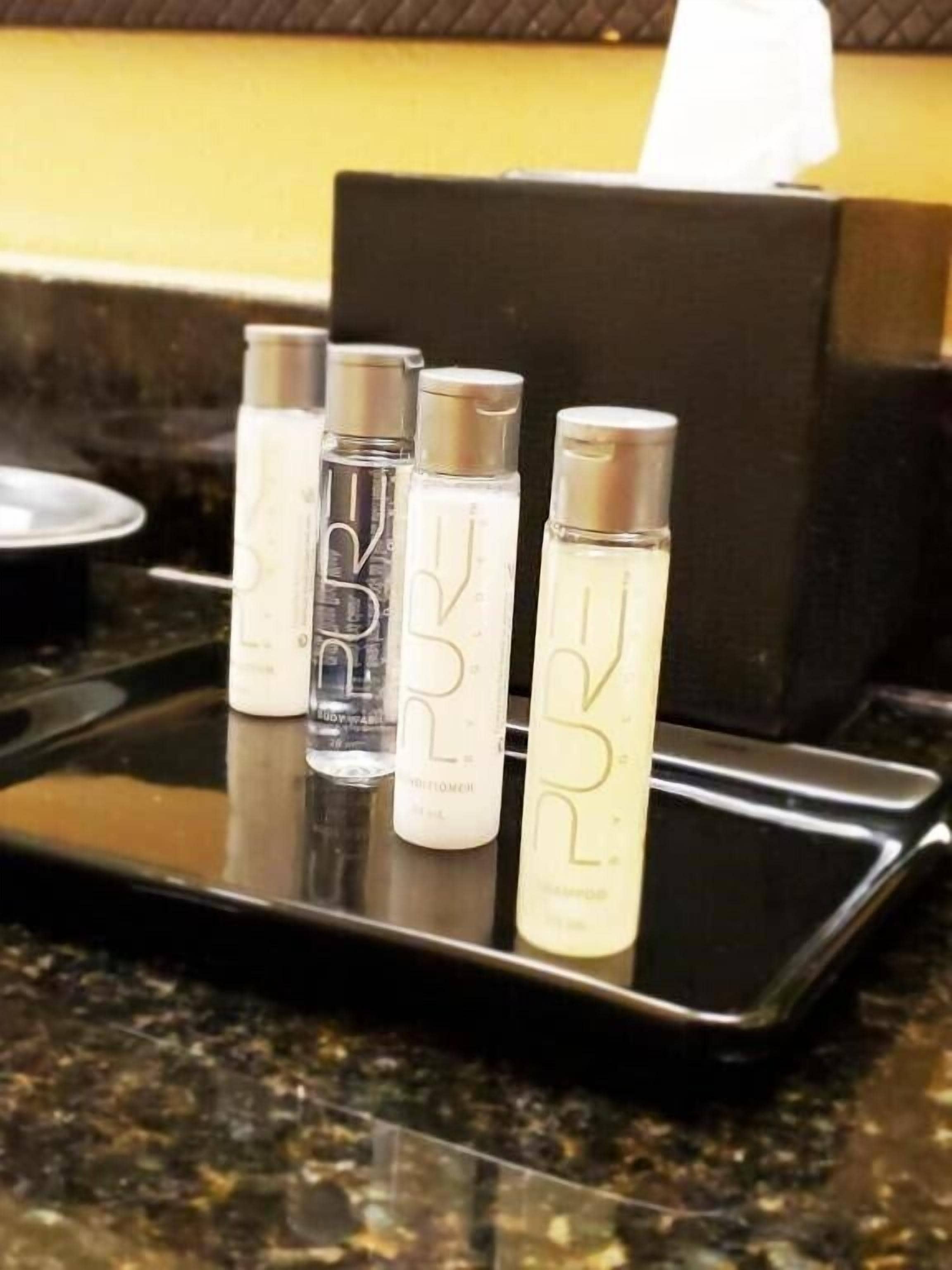 A tray with four bottles of liquid on a countertop.
