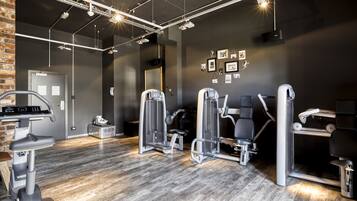 Une salle de sport équipée de matériel d’exercice, avec un miroir et une porte.