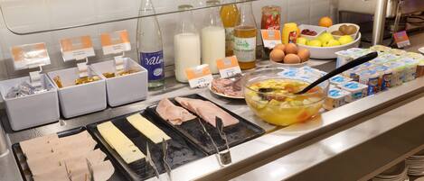 A buffet with various food items and condiments.