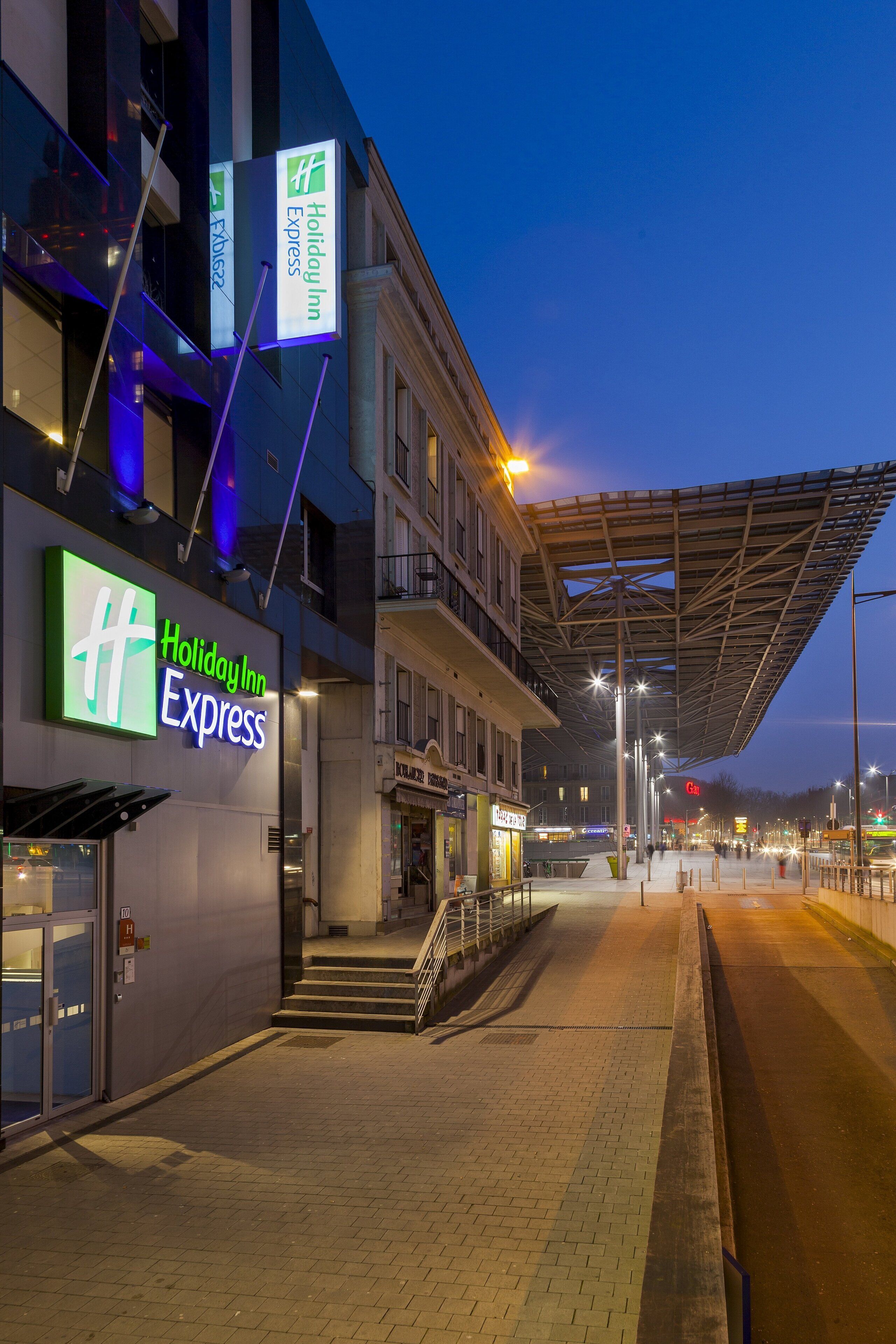A Holiday Inn Express hotel with a modern facade, a covered outdoor area, and a brick-paved entrance.