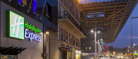 A Holiday Inn Express hotel with a modern facade, a covered outdoor area, and a brick-paved entrance.