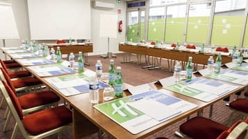 A conference room with tables set for a meeting, equipped with water bottles and name placards.